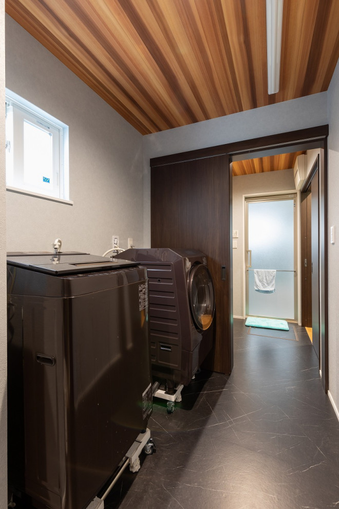 На фото: туалет с черным полом, акцентной стеной, потолком с обоями и обоями на стенах