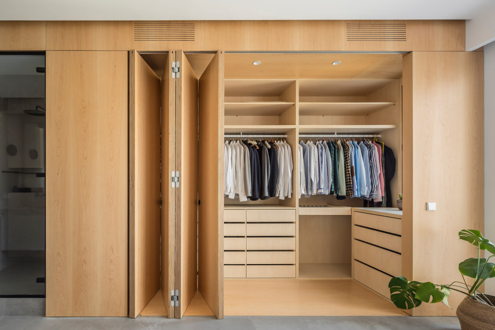 Mid-sized contemporary gender-neutral walk-in wardrobe in Valencia with recessed-panel cabinets, medium wood cabinets, ceramic floors and grey floor.
