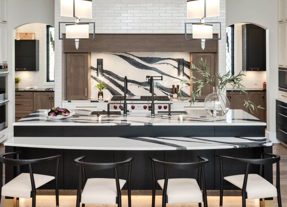 Mid-sized transitional u-shaped light wood floor and exposed beam open concept kitchen photo in Oklahoma City with an undermount sink, shaker cabinets, quartz countertops, multicolored backsplash, quartz backsplash, stainless steel appliances, an island and multicolored countertops