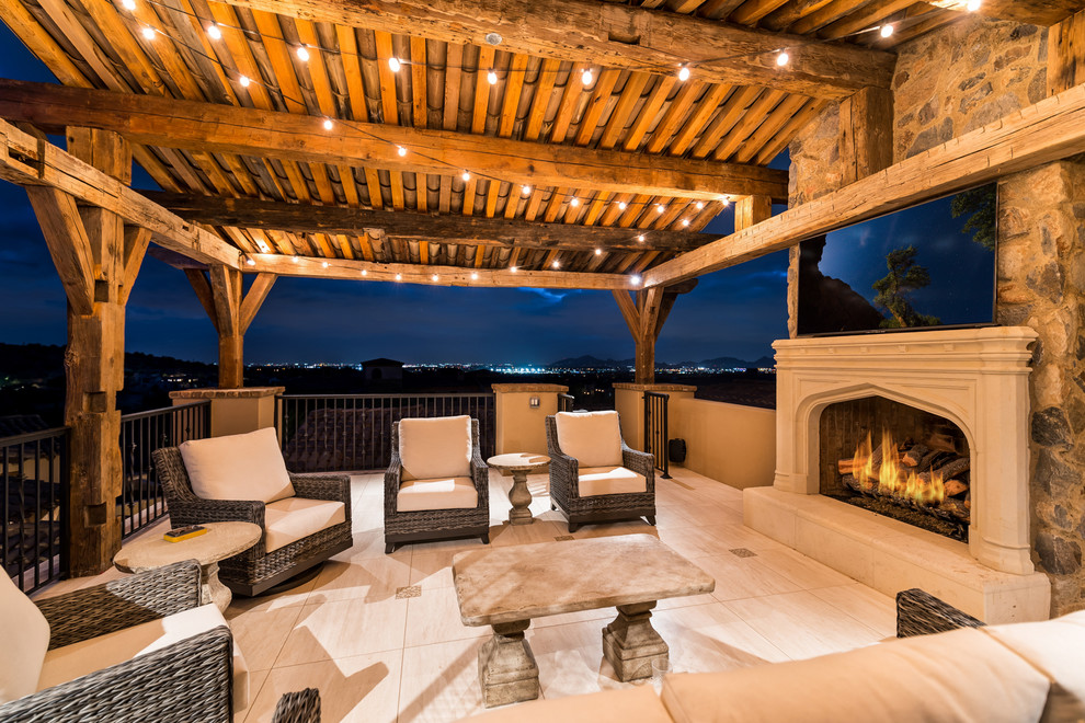 This is an example of a large mediterranean patio in Phoenix with with fireplace and a pergola.