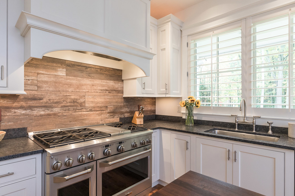 Design ideas for a large u-shaped eat-in kitchen in Portland Maine with an undermount sink, shaker cabinets, white cabinets, wood benchtops, brown splashback, cement tile splashback, stainless steel appliances, medium hardwood floors and with island.