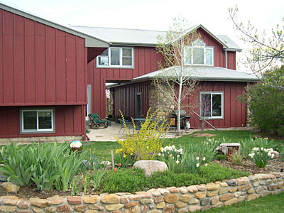 Mid-sized country two-storey red exterior in Denver with wood siding and a gable roof.
