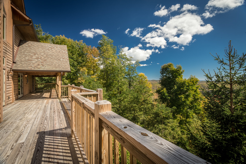 Inspiration for a huge rustic backyard deck remodel in Charlotte with a roof extension