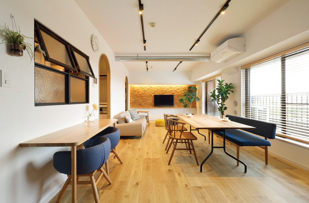Contemporary dining room in Tokyo with white walls, light hardwood floors and brown floor.