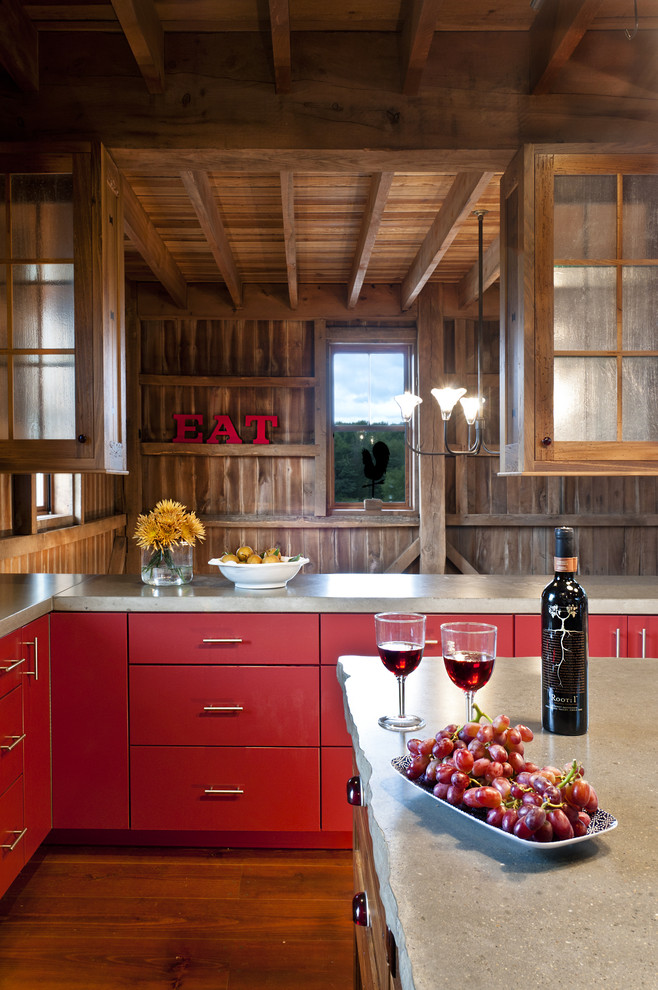 This is an example of a country kitchen in Cleveland with red cabinets, flat-panel cabinets and concrete benchtops.