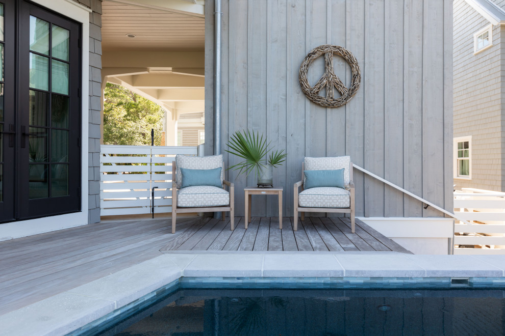 Immagine di una grande piscina naturale stile marinaro personalizzata dietro casa con pedane