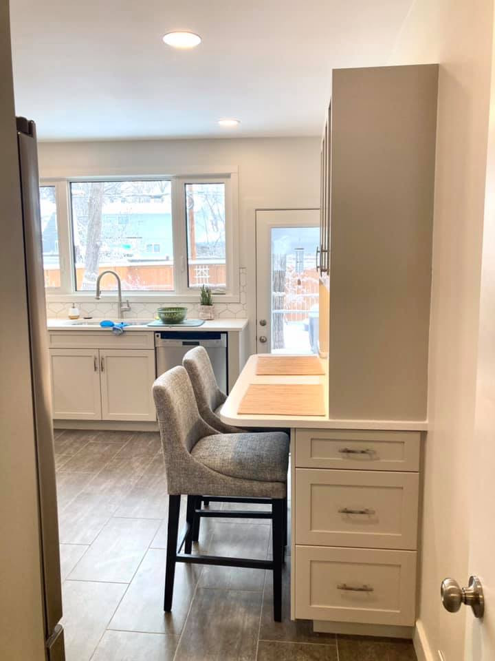 Inspiration for a mid-sized transitional u-shaped vinyl floor and gray floor enclosed kitchen remodel with an undermount sink, shaker cabinets, beige cabinets, quartz countertops, white backsplash, ceramic backsplash, stainless steel appliances and white countertops