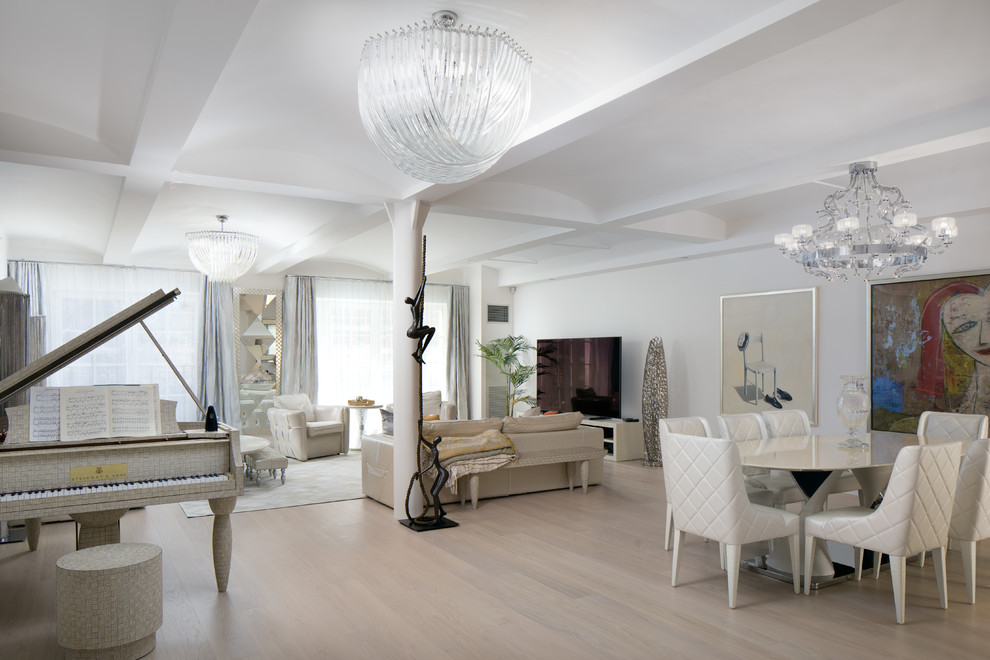 Photo of a large contemporary open concept living room in New York with white walls, light hardwood floors, a freestanding tv and beige floor.