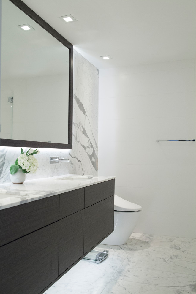 Mid-sized contemporary master bathroom in Vancouver with flat-panel cabinets, grey cabinets, a freestanding tub, an open shower, a bidet, white tile, marble, white walls, marble floors, an integrated sink, marble benchtops, white floor and a hinged shower door.