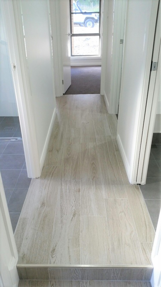 Photo of a mid-sized hallway in Newcastle - Maitland with white walls and beige floor.