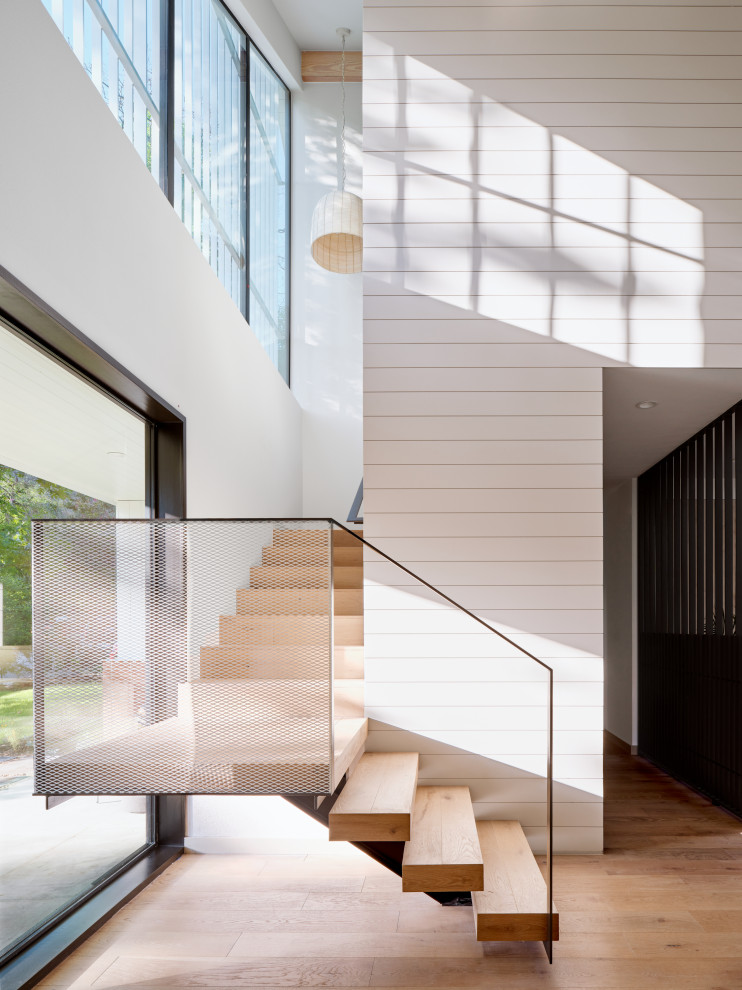 Mittelgroße Retro Holztreppe in L-Form mit Holz-Setzstufen, Stahlgeländer und Holzdielenwänden in Austin