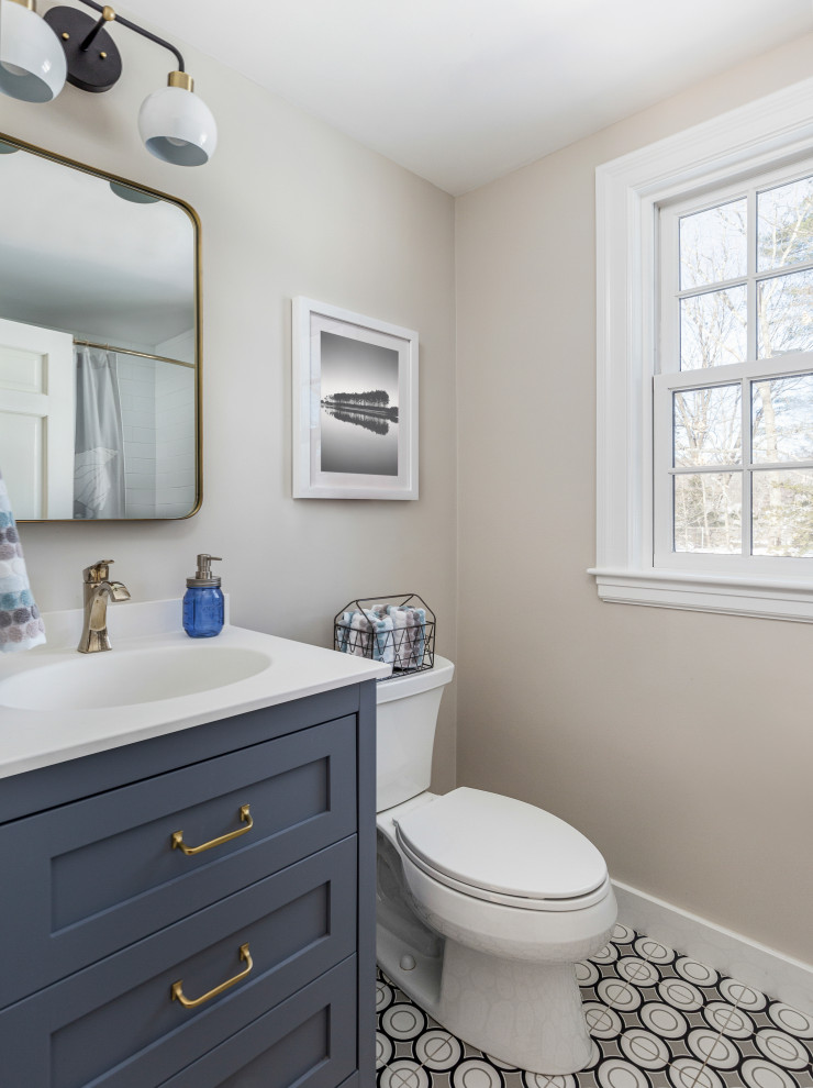 На фото: маленькая детская ванная комната в стиле неоклассика (современная классика) с фасадами в стиле шейкер, синими фасадами, ванной в нише, душем над ванной, раздельным унитазом, плиткой кабанчик, бежевыми стенами, полом из цементной плитки, врезной раковиной, столешницей из искусственного кварца, черным полом, шторкой для ванной, белой столешницей, тумбой под одну раковину и напольной тумбой для на участке и в саду