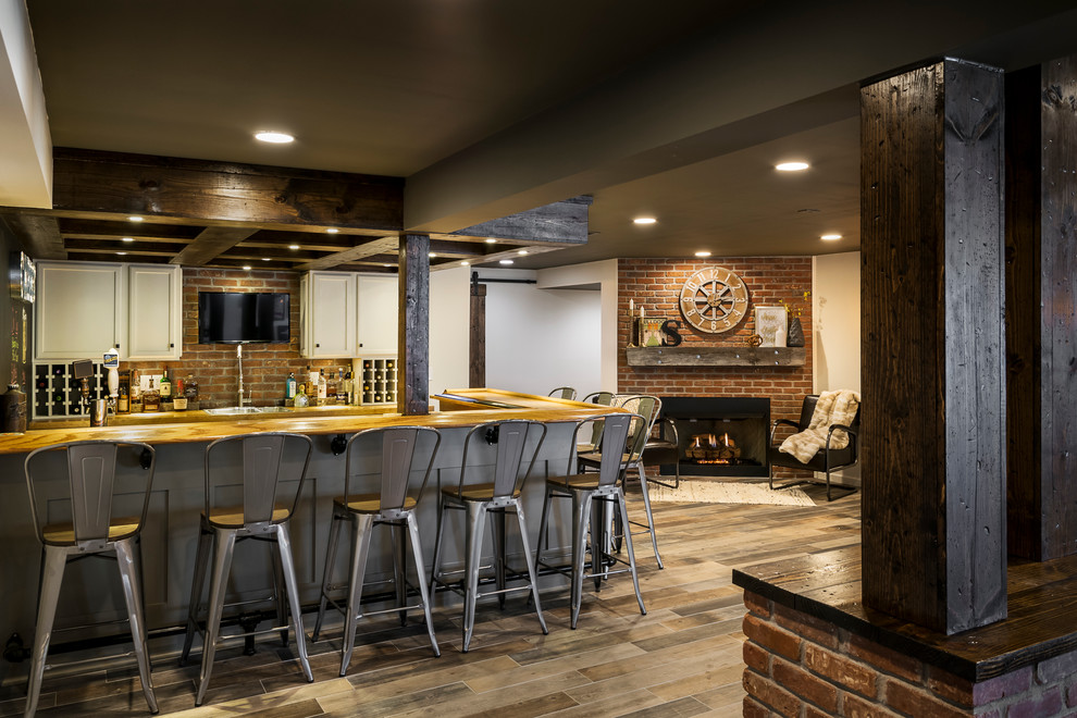 Inspiration for a large country walk-out basement in St Louis with white walls, dark hardwood floors, a standard fireplace, a brick fireplace surround and brown floor.