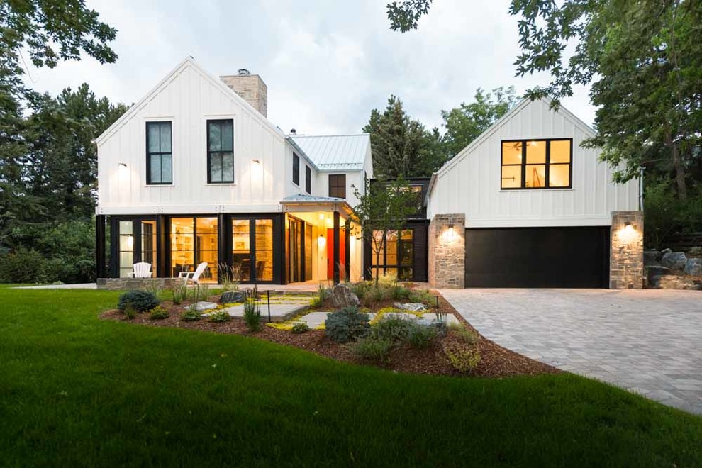 Country two-storey white house exterior in Denver with a metal roof and a gable roof.