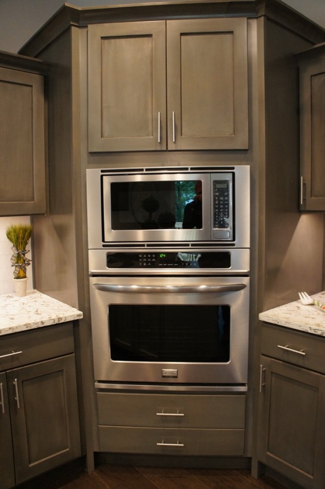 Transitional eat-in kitchen photo with flat-panel cabinets, white backsplash, stainless steel appliances and an island
