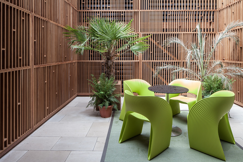 This is an example of a contemporary courtyard patio in London with a container garden.