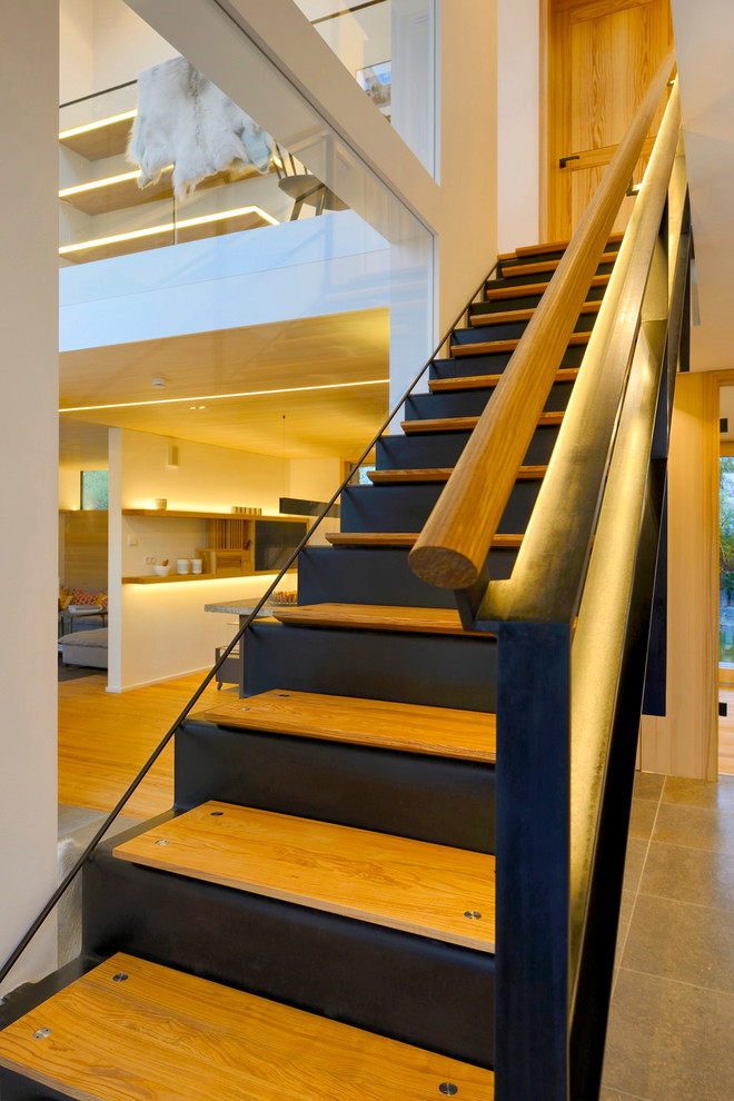 Photo of a scandinavian wood straight staircase in Other with metal risers.