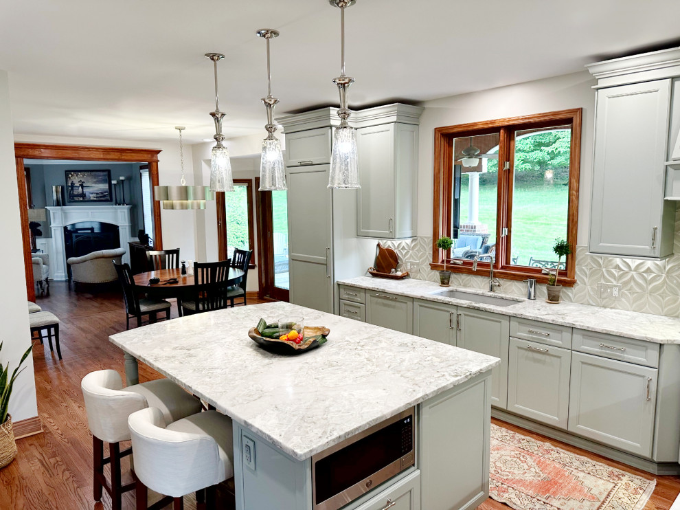 Inspiration for a transitional l-shaped medium tone wood floor eat-in kitchen remodel with shaker cabinets, green cabinets, quartzite countertops, porcelain backsplash, paneled appliances and an island