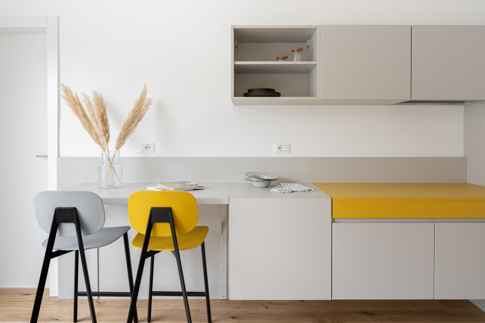 Photo of a small contemporary single-wall open plan kitchen in Other with flat-panel cabinets, yellow cabinets, medium hardwood flooring and an island.