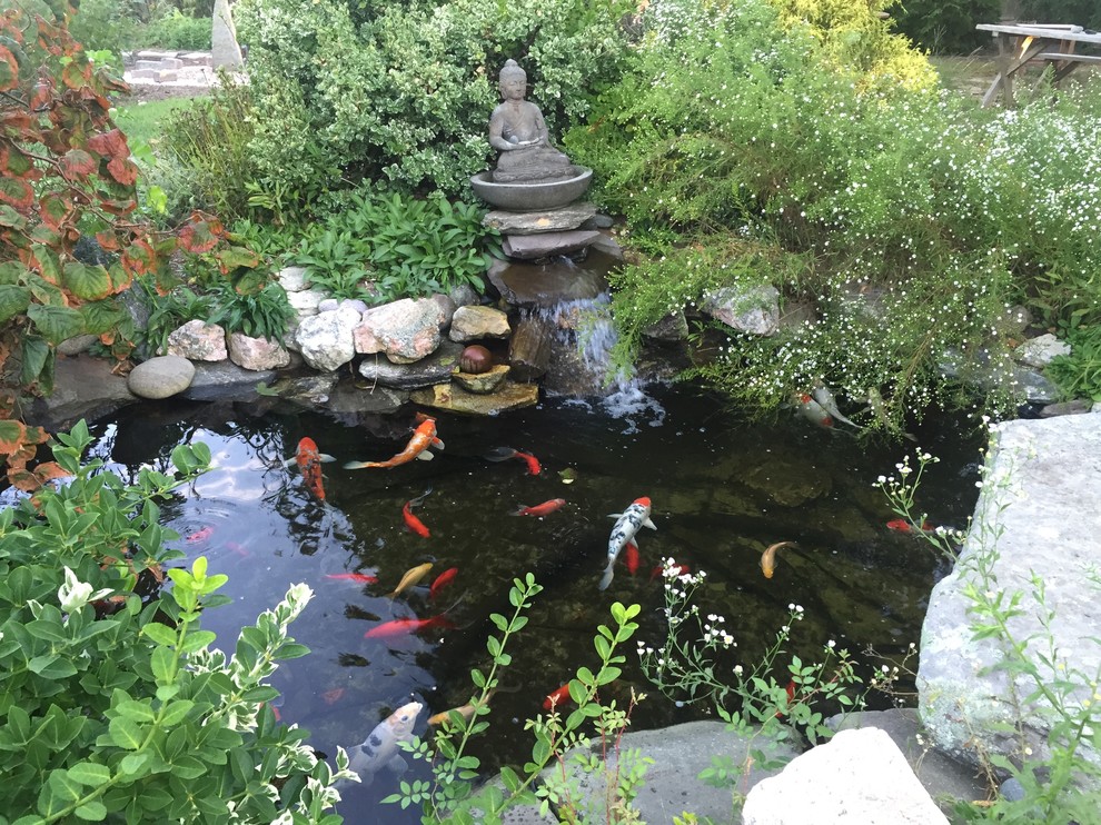 This is an example of a mid-sized tropical partial sun backyard stone formal garden in Boston for spring.