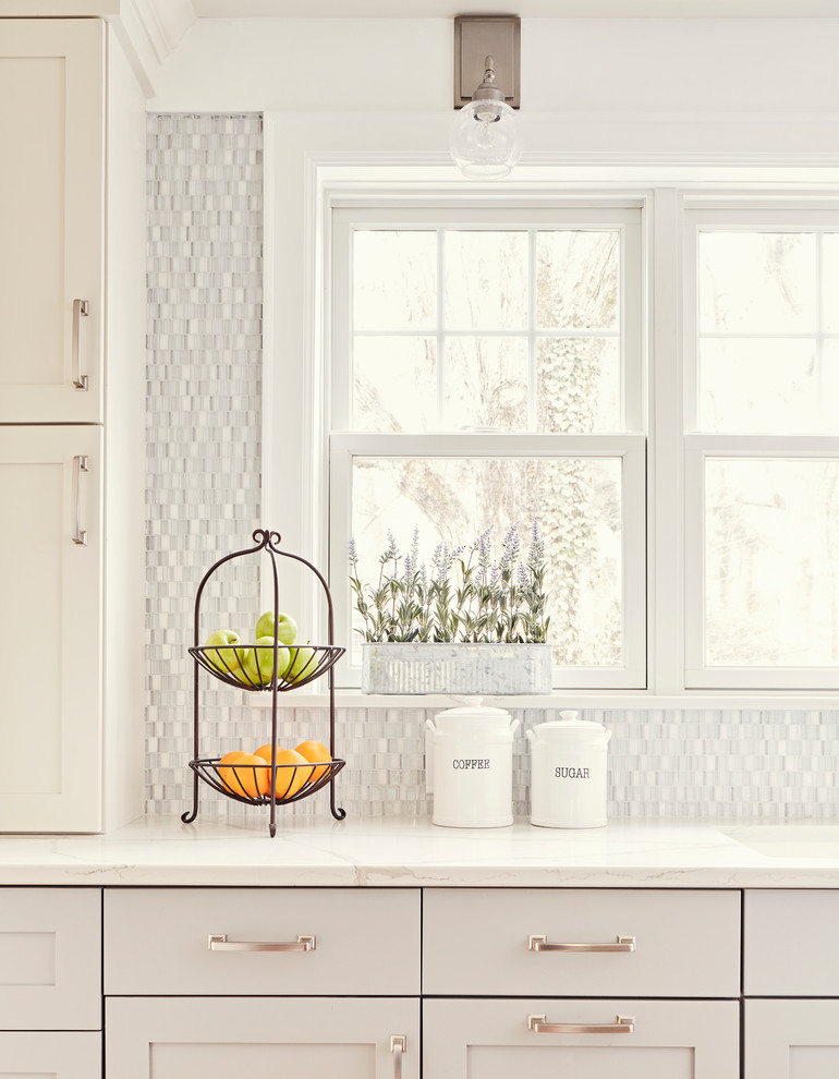 Enclosed kitchen - mid-sized transitional u-shaped medium tone wood floor and brown floor enclosed kitchen idea with an undermount sink, shaker cabinets, gray cabinets, quartz countertops, multicolored backsplash, glass sheet backsplash, stainless steel appliances, an island and white countertops