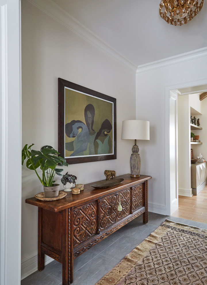 This is an example of an eclectic foyer in Chicago with white walls, porcelain floors and grey floor.