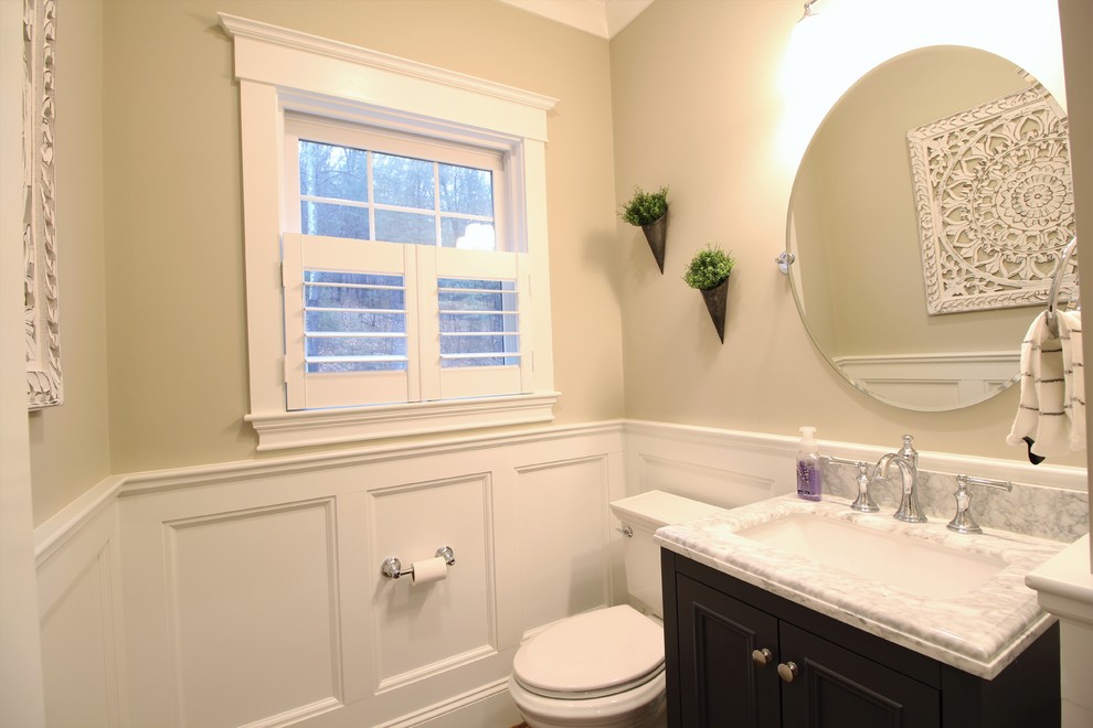 Example of a mid-sized transitional 3/4 beige tile dark wood floor and brown floor bathroom design in Boston with recessed-panel cabinets, black cabinets, a two-piece toilet, beige walls, an undermount sink, marble countertops and gray countertops