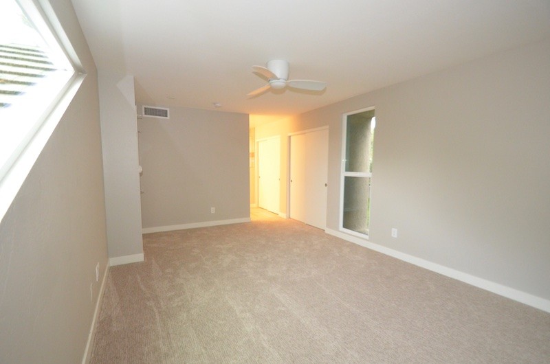 Photo of a mid-sized midcentury basement in Phoenix with beige walls, light hardwood floors and beige floor.