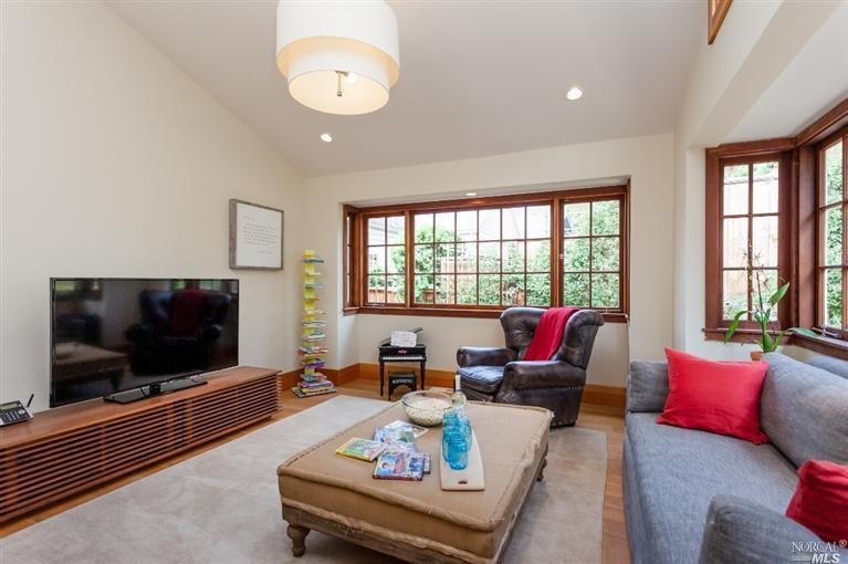 Mid-sized transitional enclosed family room in San Francisco with beige walls, medium hardwood floors, no fireplace and a freestanding tv.