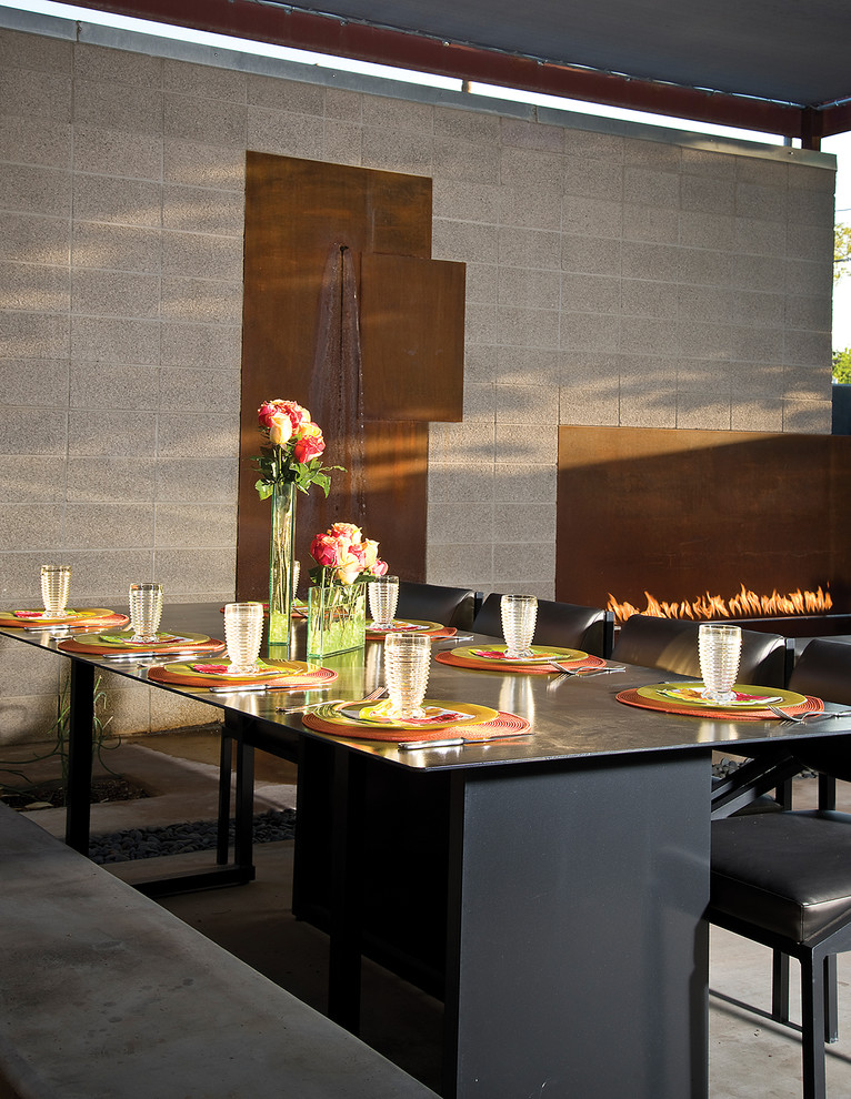 This is an example of a large contemporary open plan dining in Phoenix with brown walls, concrete floors and a ribbon fireplace.