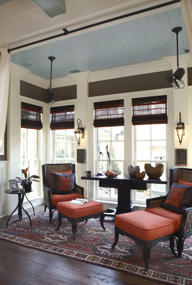 This is an example of a traditional family room in Charleston with brown walls, dark hardwood floors and brown floor.