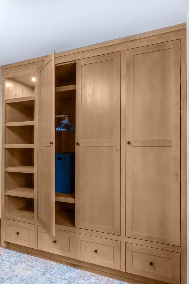 Photo of a mid-sized modern gender-neutral storage and wardrobe in Calgary with shaker cabinets and medium wood cabinets.