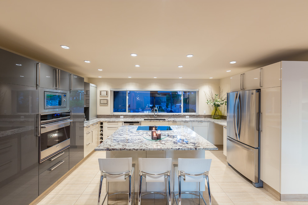 This is an example of a large contemporary u-shaped open plan kitchen in Vancouver with an undermount sink, flat-panel cabinets, white cabinets, stainless steel appliances, granite benchtops, multi-coloured splashback, mosaic tile splashback, porcelain floors and with island.