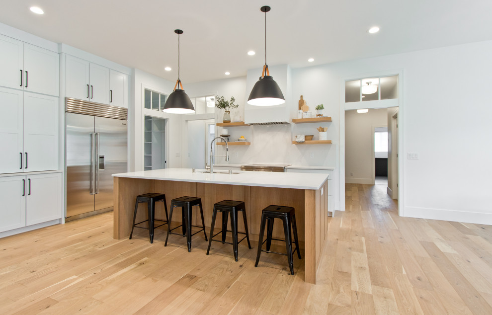 Large transitional u-shaped light wood floor and brown floor kitchen pantry photo with flat-panel cabinets, white cabinets and white backsplash