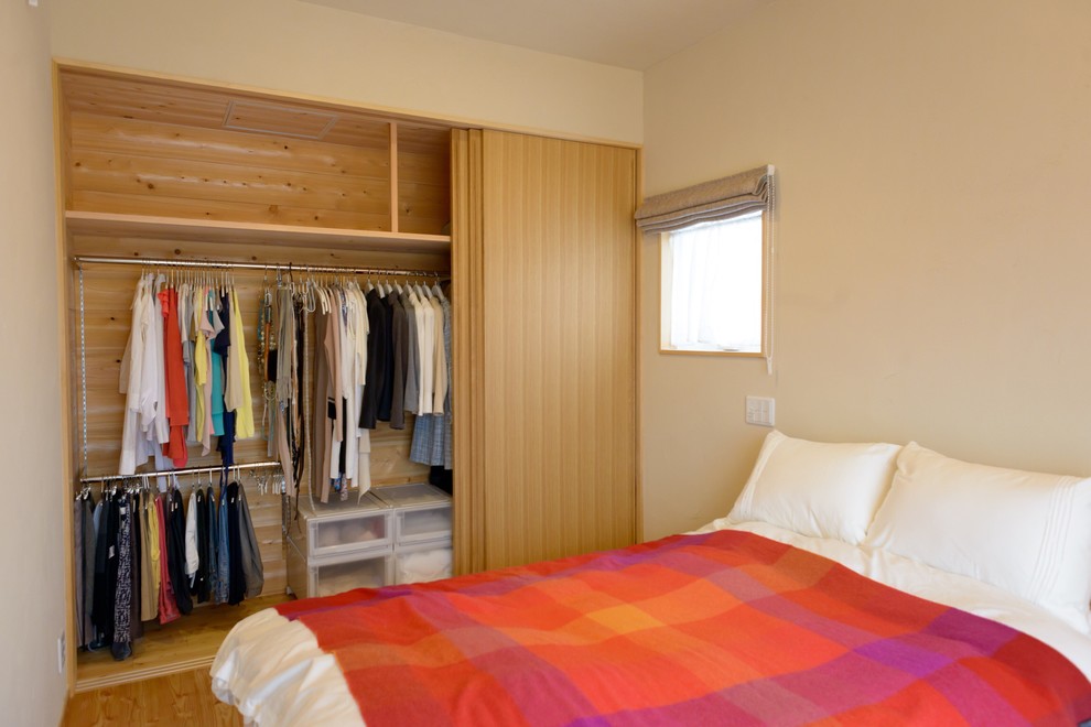 Inspiration for a mid-sized master bedroom in Other with beige walls and medium hardwood floors.