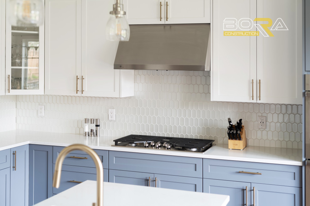 Large transitional l-shaped medium tone wood floor and brown floor eat-in kitchen photo in Seattle with an undermount sink, shaker cabinets, blue cabinets, quartz countertops, white backsplash, ceramic backsplash, stainless steel appliances, an island and white countertops