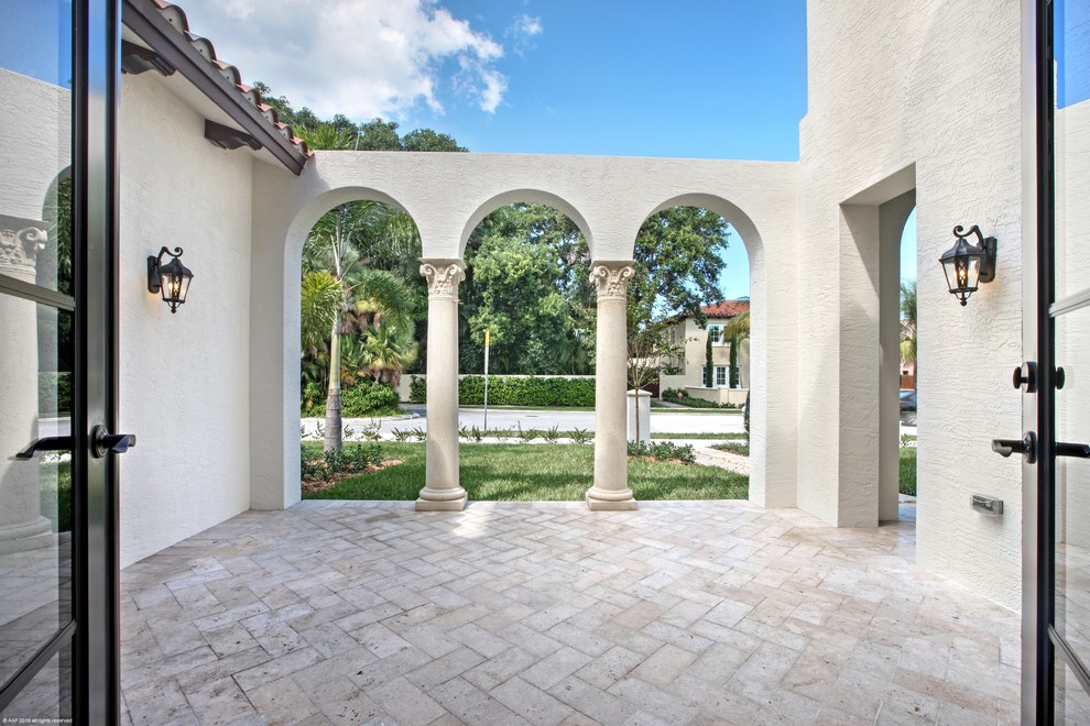 Large mediterranean courtyard patio in Miami with tile and no cover.