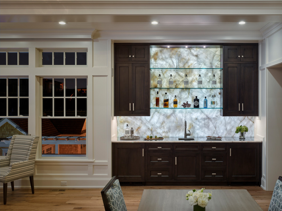 Inspiration for a mid-sized transitional single-wall wet bar in Other with an integrated sink, recessed-panel cabinets, black cabinets, grey splashback and medium hardwood floors.
