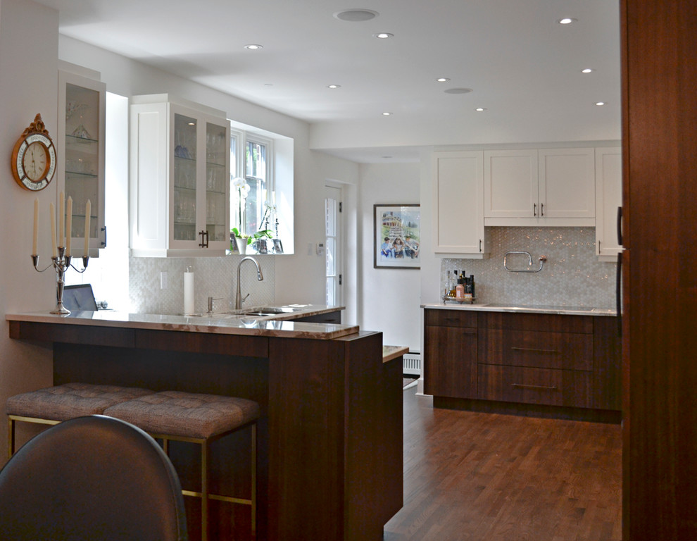 Example of a mid-sized transitional l-shaped dark wood floor eat-in kitchen design in Orange County with a double-bowl sink, shaker cabinets, white cabinets, granite countertops, gray backsplash, mosaic tile backsplash, paneled appliances and a peninsula