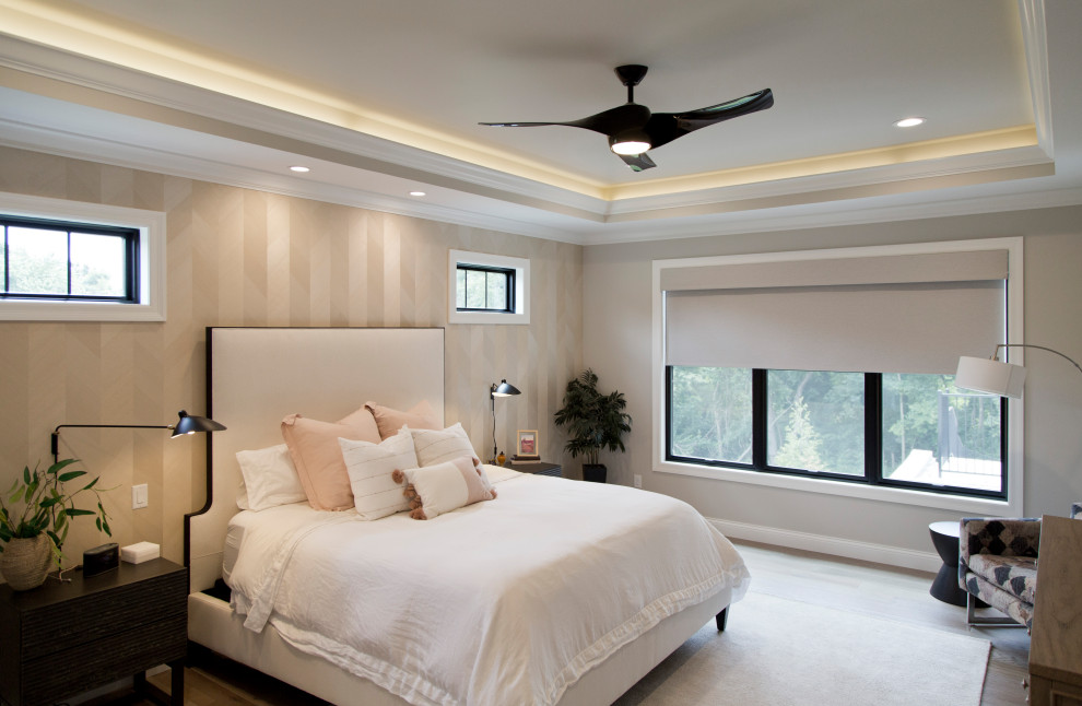 Large transitional master bedroom in St Louis with beige walls, light hardwood floors, beige floor, recessed and wallpaper.