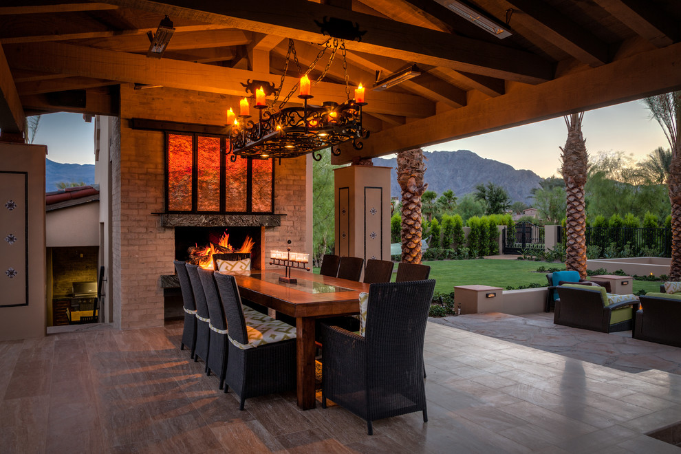 Mediterranean patio in Orange County with a fire feature, tile and a roof extension.