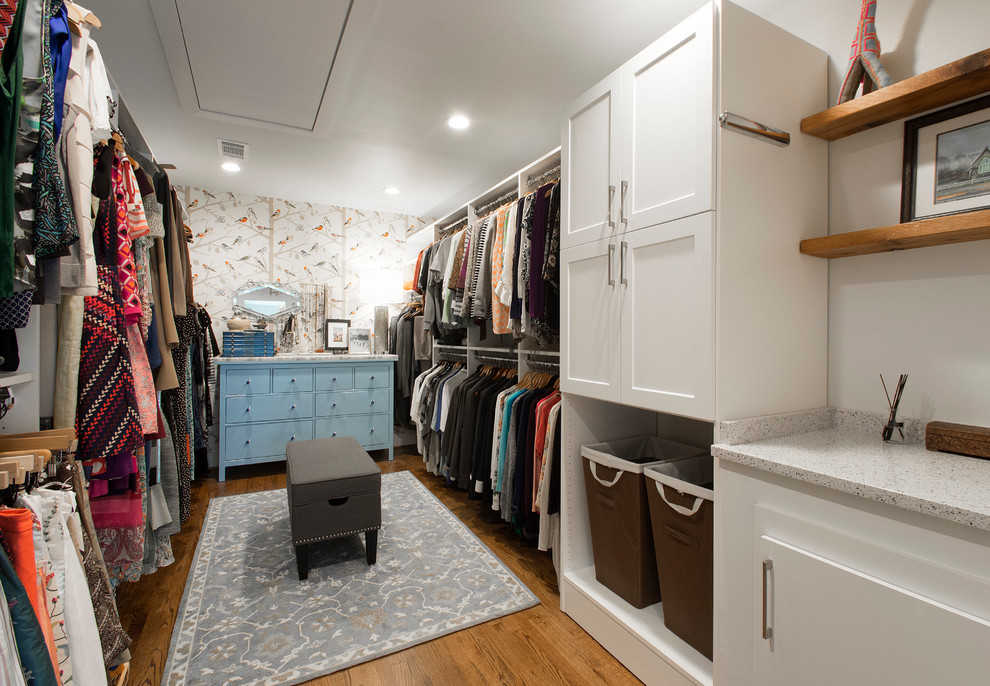 This is an example of a large eclectic gender-neutral walk-in wardrobe in Dallas with shaker cabinets, white cabinets and medium hardwood floors.