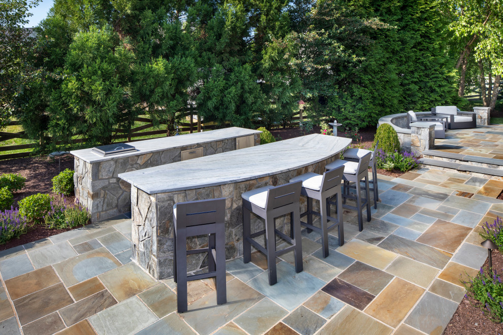 This is an example of a contemporary backyard patio in DC Metro with an outdoor kitchen and natural stone pavers.