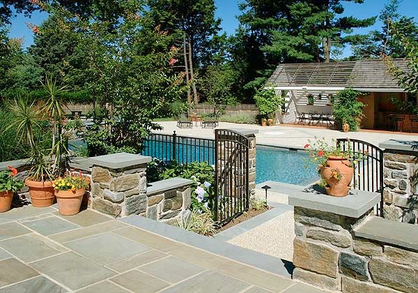 Inspiration for a mid-sized traditional backyard rectangular pool in Philadelphia with a pool house and natural stone pavers.