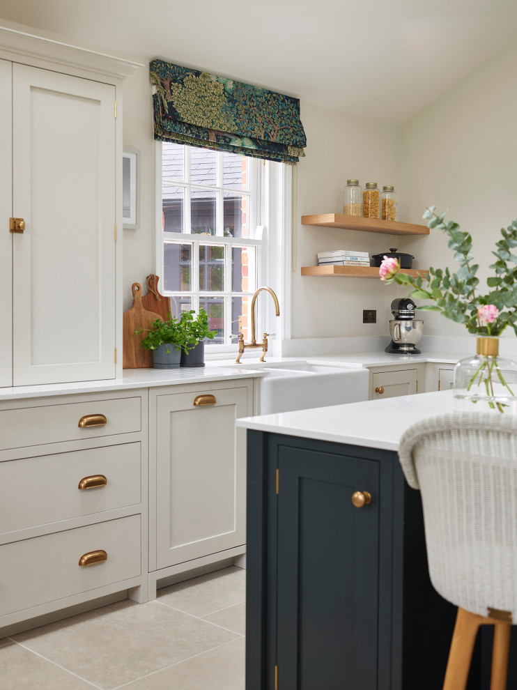 Inspiration for a traditional eat-in kitchen in Essex with a farmhouse sink, shaker cabinets, green cabinets, quartzite benchtops, white splashback, black appliances, porcelain floors, with island, grey floor, white benchtop and vaulted.