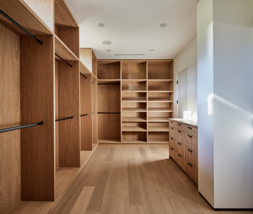Idee per una grande cabina armadio unisex minimalista con ante lisce, ante in legno chiaro, parquet chiaro e pavimento beige