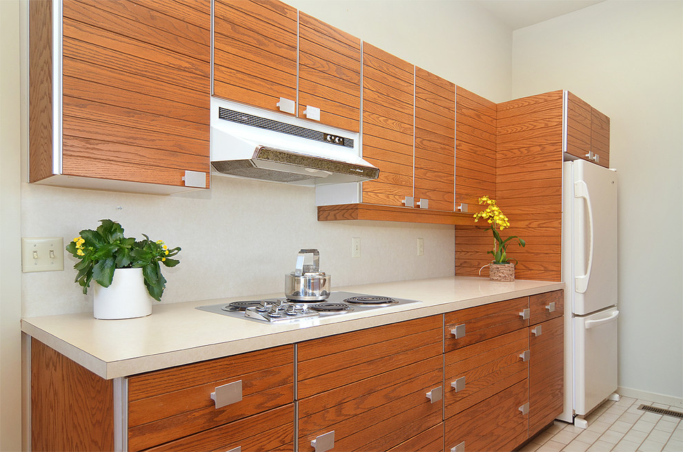 Photo of a mid-sized midcentury galley eat-in kitchen in Seattle with medium wood cabinets, laminate benchtops, white appliances, ceramic floors and flat-panel cabinets.