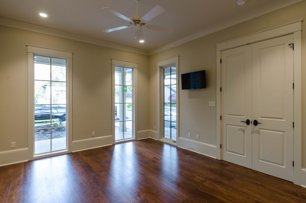 Mid-sized guest bedroom in Other with beige walls, dark hardwood floors and brown floor.