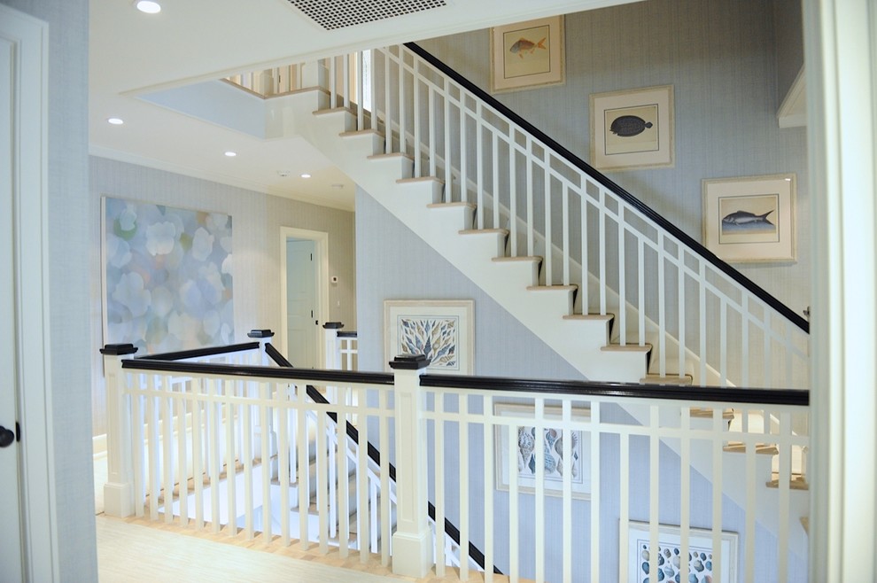 Design ideas for a large beach style wood l-shaped staircase in New York with wood risers and wood railing.
