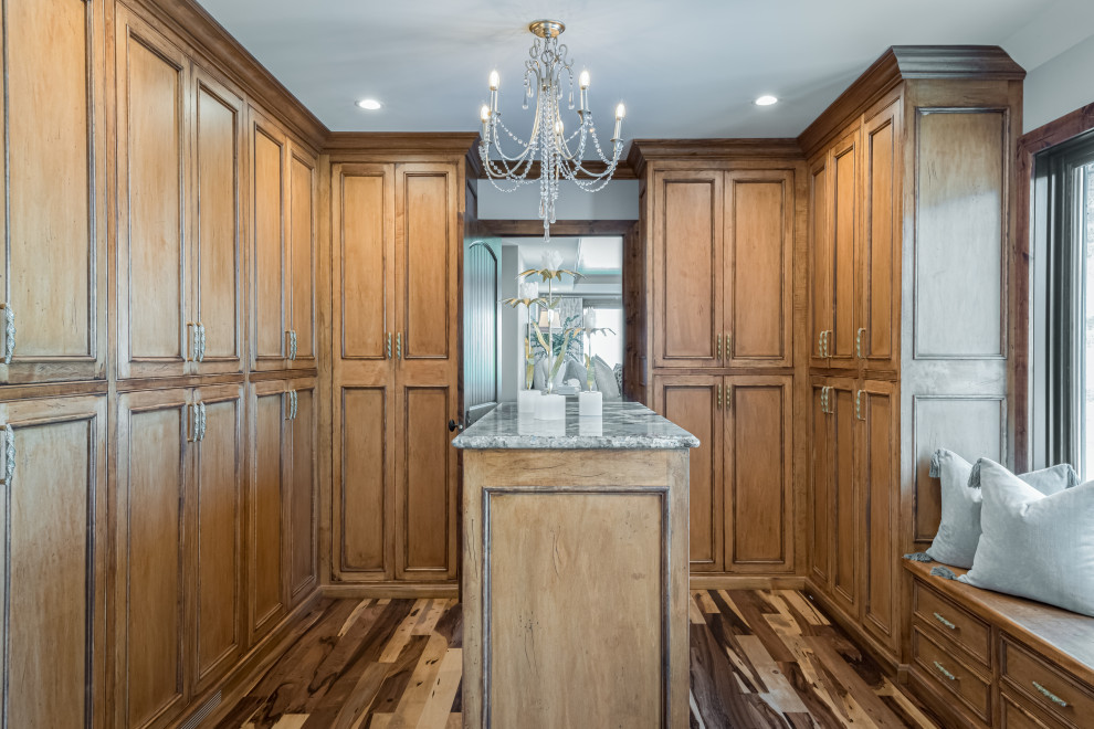 Large transitional gender-neutral storage and wardrobe in Milwaukee with recessed-panel cabinets, medium wood cabinets, medium hardwood floors and multi-coloured floor.
